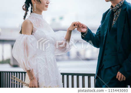 A bride and groom holding hands 115443093