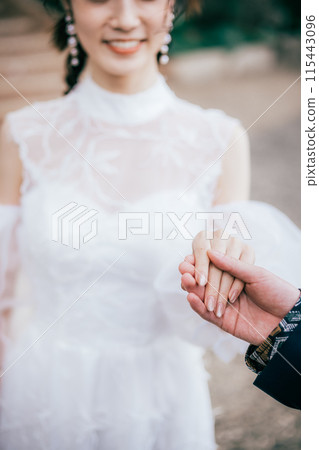 A bride and groom holding hands 115443096