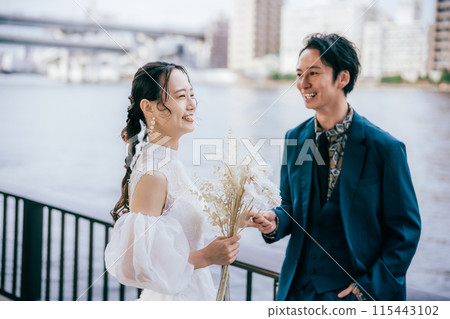 Bride and groom chatting while holding hands 115443102