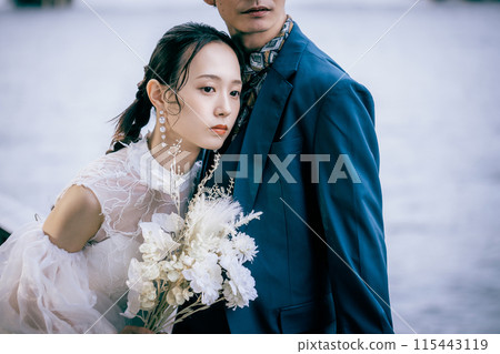 Bride pressing her ear to the groom's chest 115443119