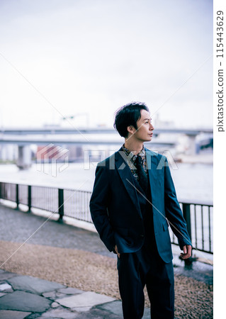 Businessman walking along the river 115443629