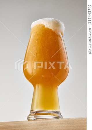 Photo of mug filled with crafted, golden beer against grey studio background. Traditional alcohol drink of Oktoberfest. Photo of mug filled with crafted, golden beer against grey studio background. Traditional alcohol drink of Oktoberfest. 115443742