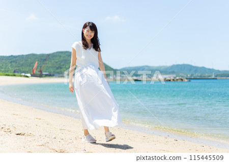 A woman standing by the sea 115445509