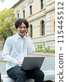 Man using laptop and making phone call outdoors 115445512