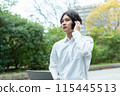 Man using laptop and making phone call outdoors 115445513