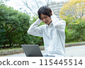 A man worried while using a laptop outdoors 115445514