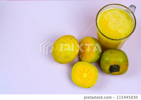 a glass of persimmon lemonade. Persimmon lemonade is a refreshing drink. 115445830