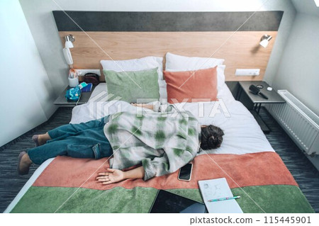 student who has fallen asleep amidst their study materials, highlighting the intense demands of academic life student who has fallen asleep amidst their study materials, highlighting the intense demands of academic life 115445901
