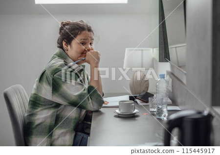 woman smiling while working at her desk, illustrating how a positive attitude and a pleasant work environment can make everyday tasks more enjoyable and fulfilling woman smiling while working at her desk, illustrating how a positive attitude and a pleasant work environment can make everyday tasks more enjoyable and fulfilling 115445917