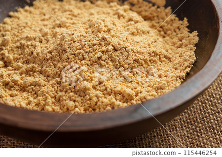 Peanut flour in a wooden bowl. The fine golden nut powder is a versatile ingredient for baking, cooking, and adding texture and flavor. Peanut flour in a wooden bowl. The fine golden nut powder is a versatile ingredient for baking, cooking, and adding texture and flavor. 115446254