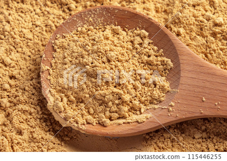 Peanut flour in a wooden spoon. Culinary fine golden nut powder is a versatile ingredient for baking Peanut flour in a wooden spoon. Culinary fine golden nut powder is a versatile ingredient for baking 115446255