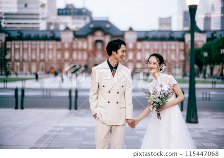 A couple walking and laughing in front of Tokyo Station 115447068