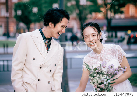 A couple walking and laughing in front of Tokyo Station 115447073