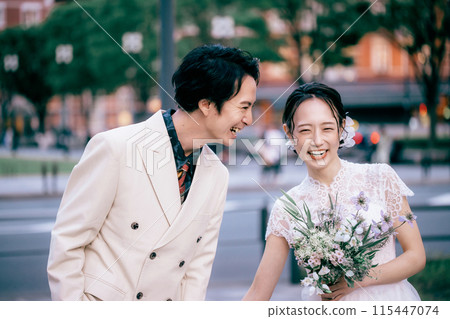 A couple walking and laughing in front of Tokyo Station 115447074
