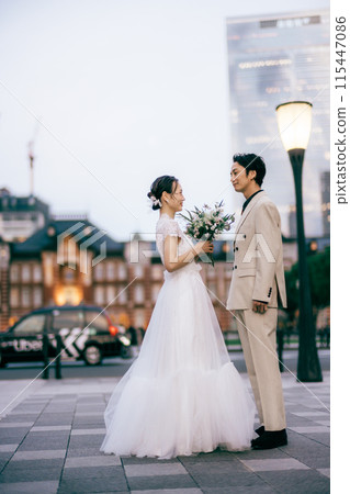 Bride and groom facing each other in front of Tokyo Station Bride and groom facing each other in front of Tokyo Station 115447086