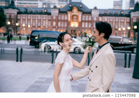 Bride fooling around with bouquet at Tokyo Station photoshoot 115447098