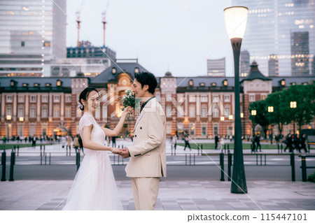 Bride fooling around with bouquet at Tokyo Station photoshoot 115447101