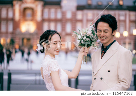 Bride fooling around with bouquet at Tokyo Station photoshoot 115447102