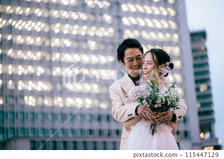 Bride being hugged from behind by groom in front of Tokyo Station 115447129