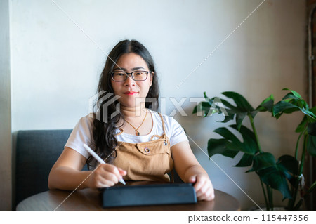 Portrait asian freelance people business female wearing glasses stylish hipste Draw or taking note on digital tablet with electronic pen for browsing internet, chatting and blogging in coffee shop. Portrait asian freelance people business female wearing glasses stylish hipste Draw or taking note on digital tablet with electronic pen for browsing internet, chatting and blogging in coffee shop. 115447356