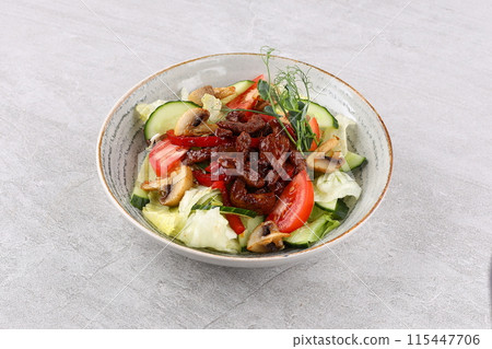 Asian beef salad with vegetables and nuts in a white bowl on a dark background. Asian food concept. Asian beef salad with vegetables and nuts in a white bowl on a dark background. Asian food concept. 115447706
