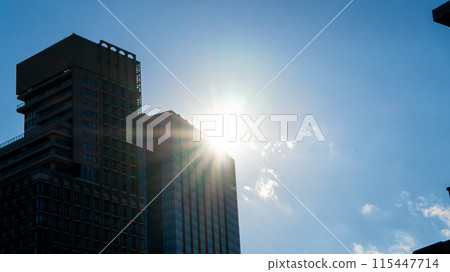 The sun peeking through the buildings 115447714