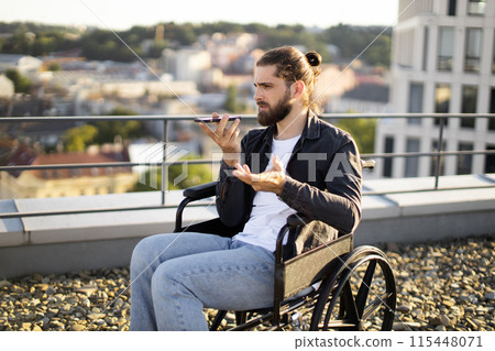 Man in wheelchair talking on smartphone on rooftop overlooking cityscape Man in wheelchair talking on smartphone on rooftop overlooking cityscape 115448071
