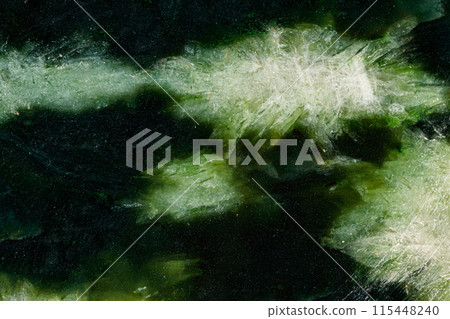 Macro stone Nephrite mineral on white background Macro stone Nephrite mineral on white background 115448240