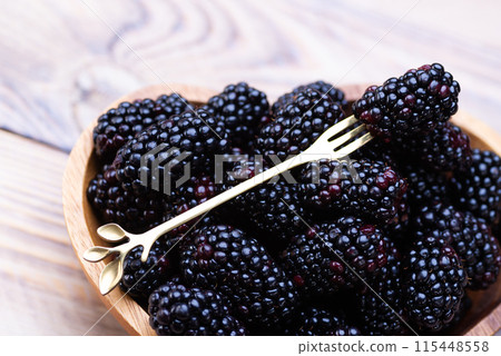 Fresh blackberries on a wooden plate Fresh blackberries on a wooden plate 115448558