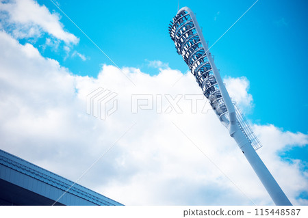 Stadium light with copy space. Stadium floodlights against a clear blue sky Stadium light with copy space. Stadium floodlights against a clear blue sky 115448587