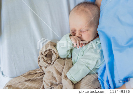 A baby lies with the mother after childbirth, resting peacefully. The serene moment captures the bond between mother and child as they begin their journey together. The hospital environment ensures a 115449386