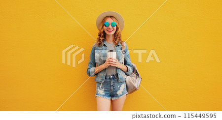 Summer stylish happy young woman with cup of coffee wearing summer hat on yellow background Summer stylish happy young woman with cup of coffee wearing summer hat on yellow background 115449595
