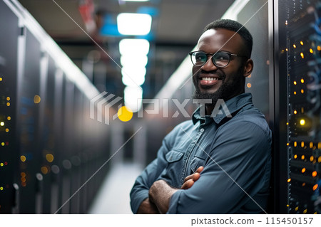 Engineer Standing and Posing with Crossed Arms in the Middle of a Working Data Center Server Room 115450157