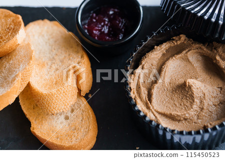 Pate with sauce and croutons on a black board Pate with sauce and croutons on a black board 115450523
