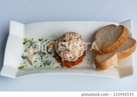 Cheese balls with herbs on a black board on a white background Cheese balls with herbs on a black board on a white background 115450535