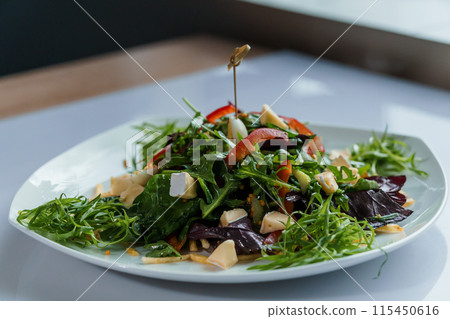 Salad with cabbage, cucumber, egg, onion, tuna and olive oil on a white saucer on a white background Salad with cabbage, cucumber, egg, onion, tuna and olive oil on a white saucer on a white background 115450616