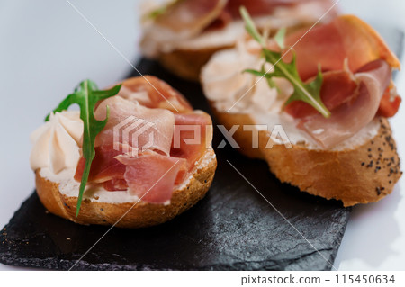 Canapes with sun-dried tomato and salami 115450634