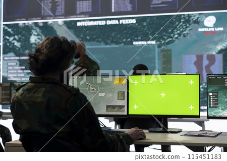IT operator works with isolated display and tracking hostile vessels, transmitting gps location to the national guard power base. Military recruit operates on CCTV satellite system. 115451183