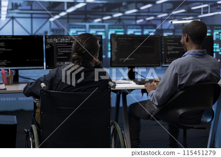 Person with paraplegia and colleague working in inclusive server hub workspace, typing on PC. Woman in wheelchair and coworker doing tasks in data center housing advanced data storage infrastructure Person with paraplegia and colleague working in inclusive server hub workspace, typing on PC. Woman in wheelchair and coworker doing tasks in data center housing advanced data storage infrastructure 115451279