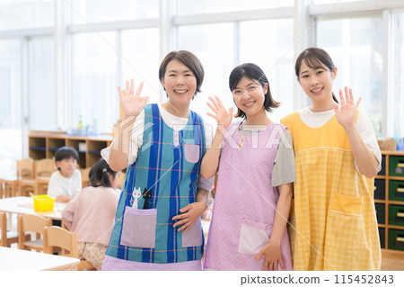Image of nursery school and after-school care staff and teachers waving (bye-bye) Multiple young and veteran teachers looking at the camera 115452843