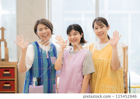 Image of nursery school and after-school care staff and teachers waving (bye-bye) Multiple young and veteran teachers looking at the camera 115452846