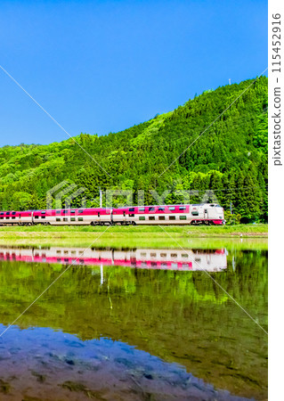 Hakubi Line: Sunrise Izumo train running through the green rice fields (Neu-Kurosaka) 115452916