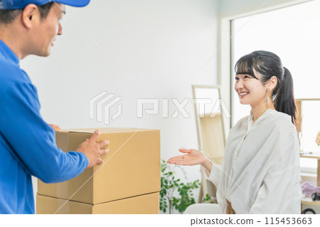 A female customer and a male delivery person requesting collection of a parcel 115453663