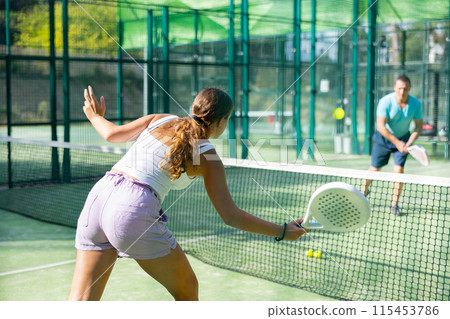 European woman tennis player in padel tennis playing on the outdoor court European woman tennis player in padel tennis playing on the outdoor court 115453786