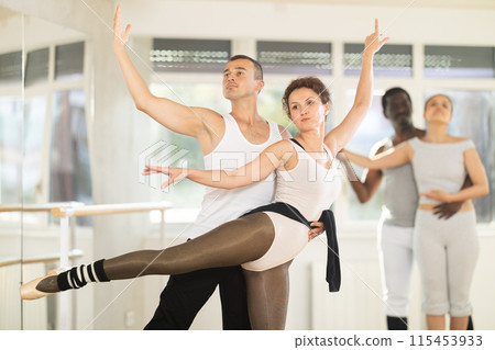 Couple of ballet dancers showcasing supports during group class Couple of ballet dancers showcasing supports during group class 115453933