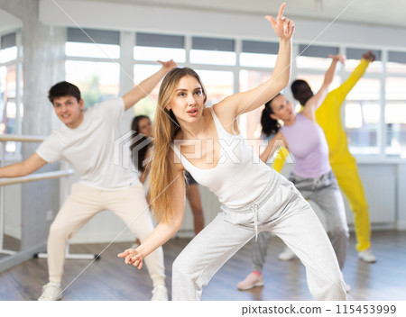Girl with team of young like-minded people learn to dance modern dances 115453999