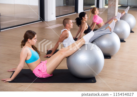Young adults training pilates at group class 115454027
