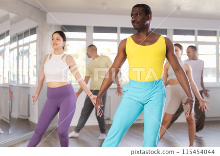 African american man dancing expressive salsa during group class 115454044
