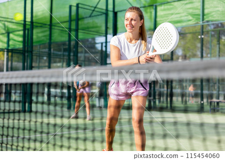 European woman padel tennis player trains on the outdoor court European woman padel tennis player trains on the outdoor court 115454060