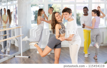 Man and young woman dancing waltz in couple during lesson at studio 115454119
